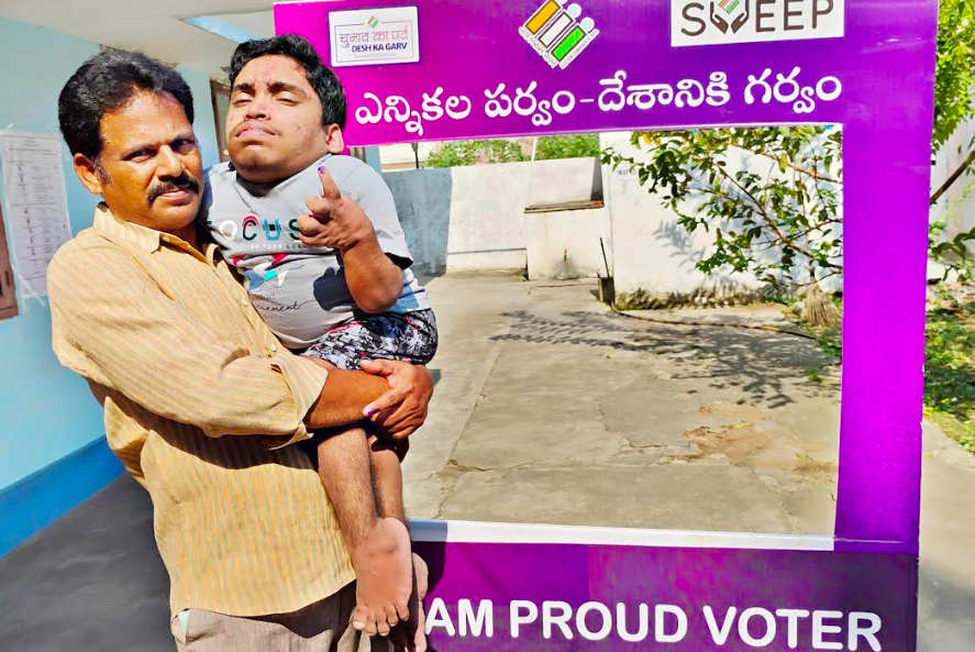 A physically challenged person casts his vote with the help of another person at D.Seetharatnam memorial school  in Rajamahendravaram on Monday.  - A.MANIKANTA KUMAR
