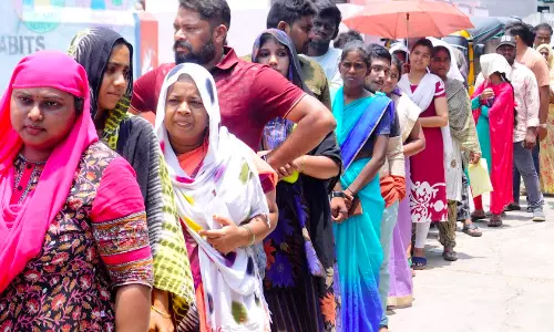 People wait in a queue under hot sun to cast their vote at a polling booth of Subbarao Nagar municipal school in Rajamahendravaram on Monday.  - A.MANIKANTA KUMAR