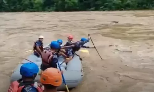 Rescuers recover the first body from two buses swept by a landslide and fell into a river in Nepal