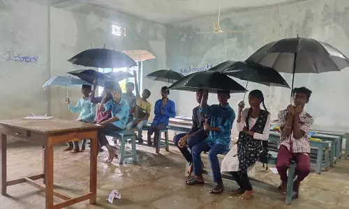 Mancherial: Students protest leaking building by holding umbrellas in classrooms