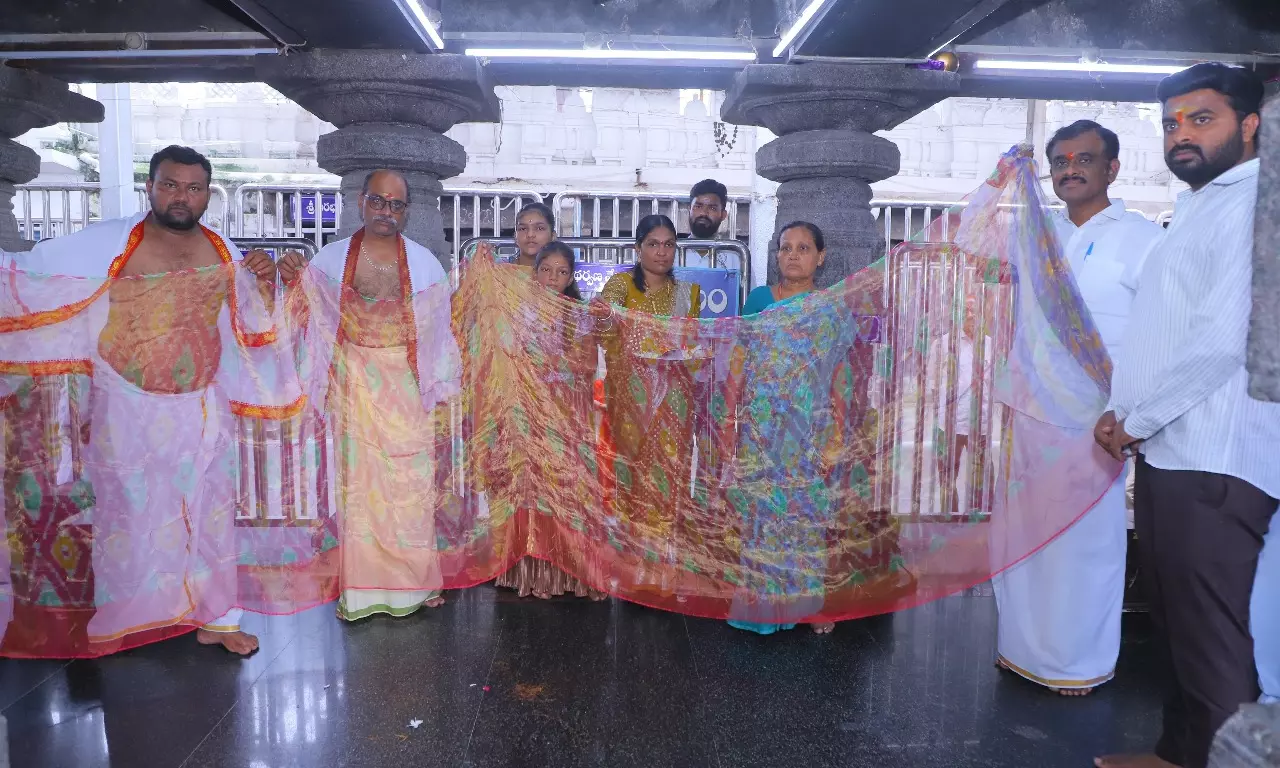 Sircilla weaver presents matchboxes with sari and shawl to Vemulawada temple