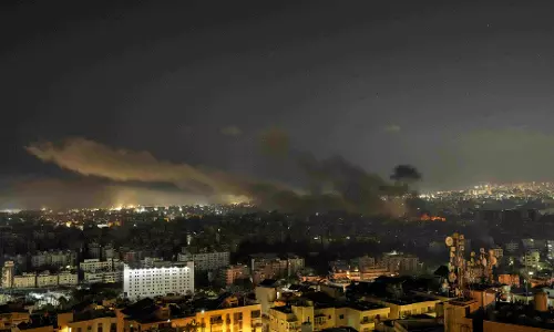 Israeli airstrikes rock suburbs of Beirut and cut off a key crossing into Syria