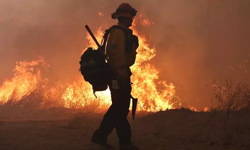 California wildfire burns out of control but firefighters could get a break when winds diminish