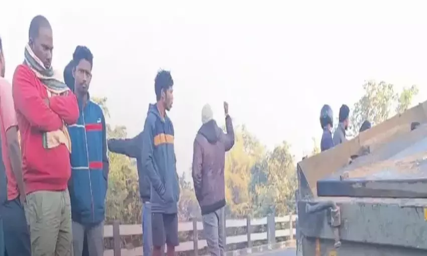 Truck hangs precariously from river bridge after breaking fence wall