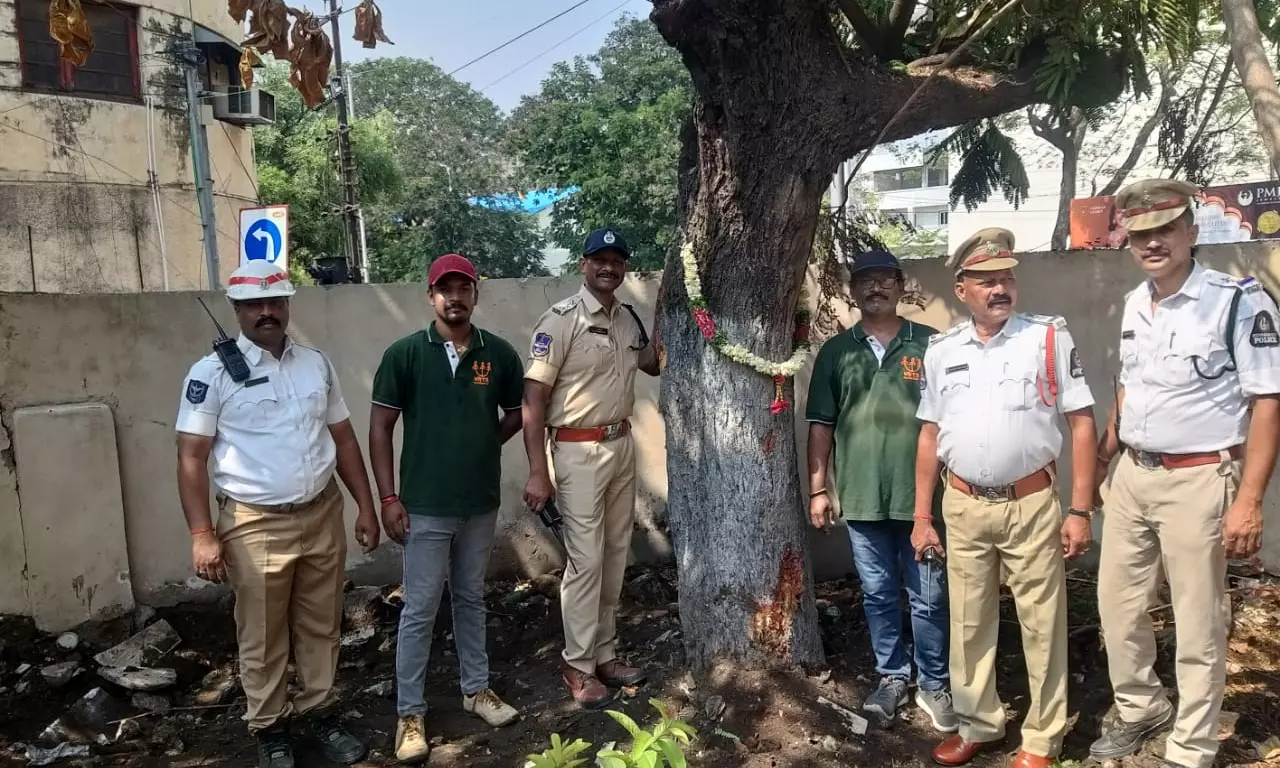 Traffic police stand in front of a ‘konda chinta’ tree that was translocated from in front of the Mahbub College in Secunderabad Traffic police stand in front of a ‘konda chinta’ tree that was translocated from in front of the Mahbub College in Secunderabad