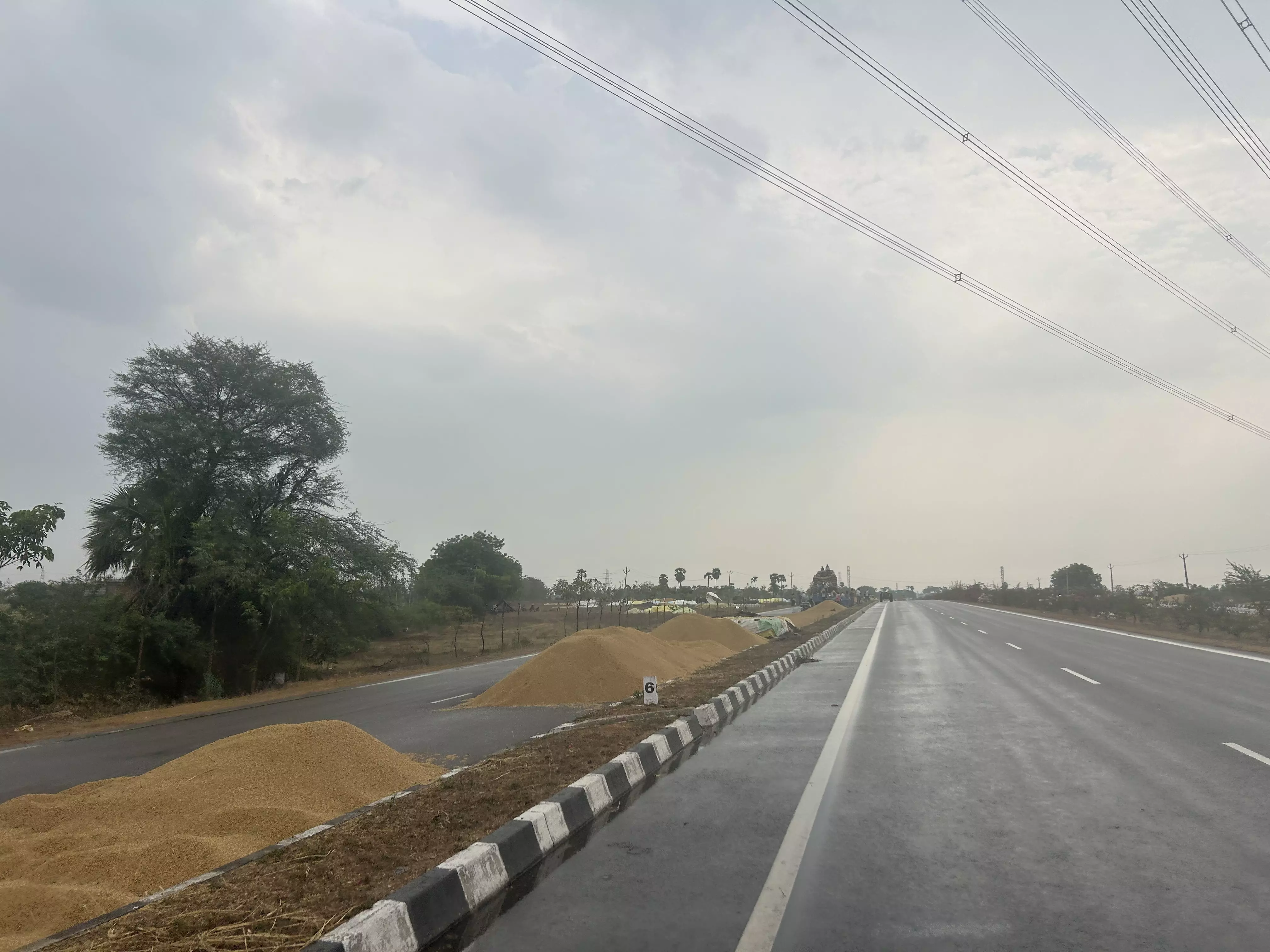 Farmers forced to dry harvested paddy on service roads