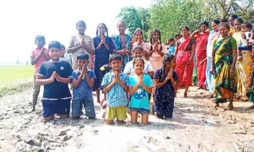Villagers Kneel in Slushy Mud For Road to Hamlet